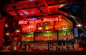 Rot beleuchtete Bar mit dem Schriftzug "Mexico es Mezcal"